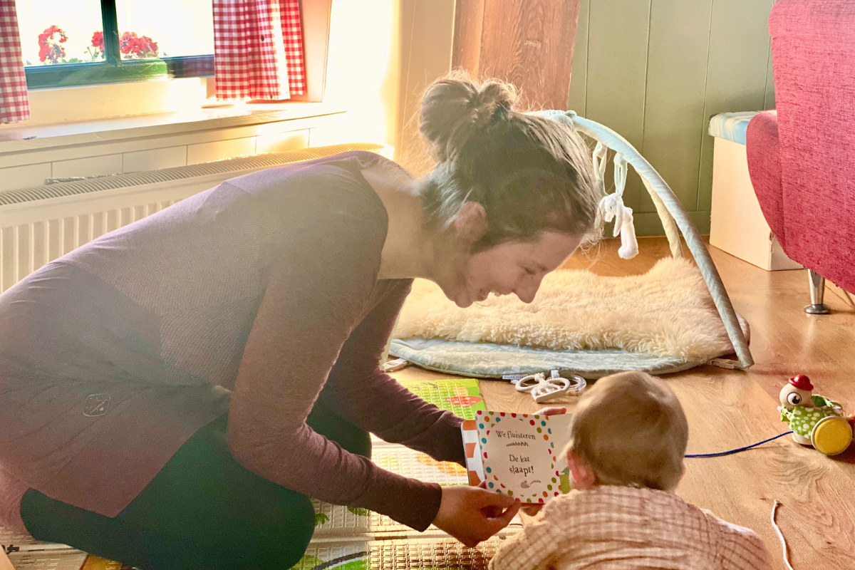 women reading a book to a baby in the playroom