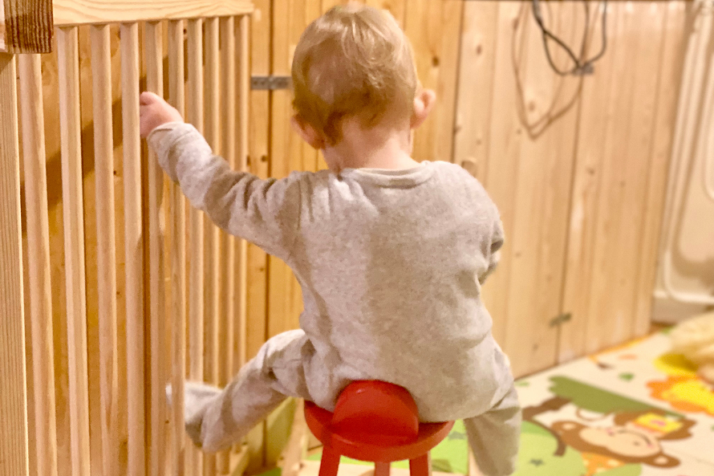 baby sitting on a rocking horse with cloth diaper