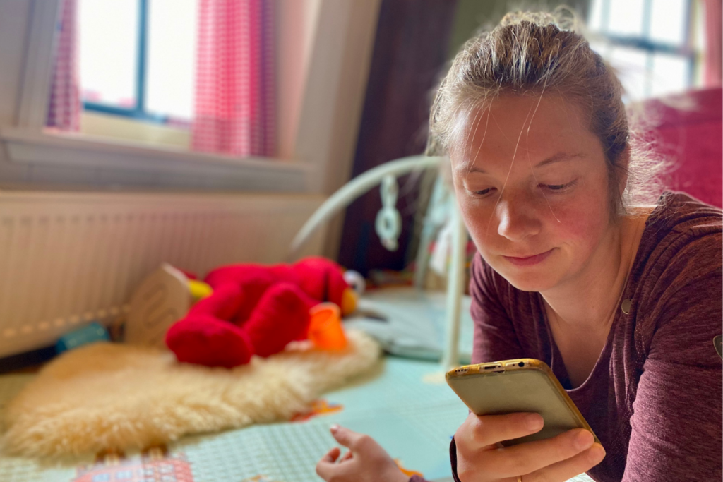 women spending time at phone laying in playroom 