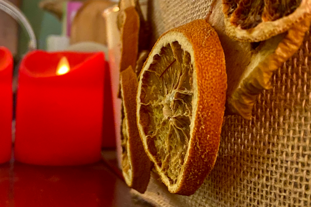 orange and apples slices with red candle in the background