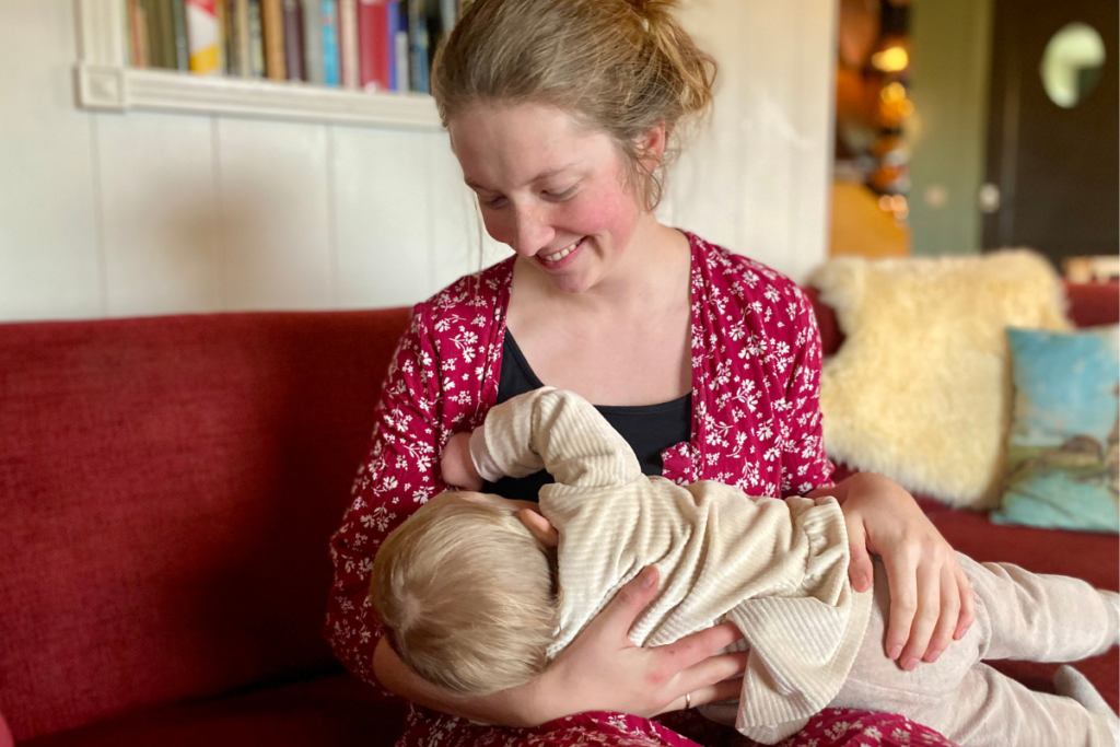 Women discreetly breastfeeding her baby with red dress 