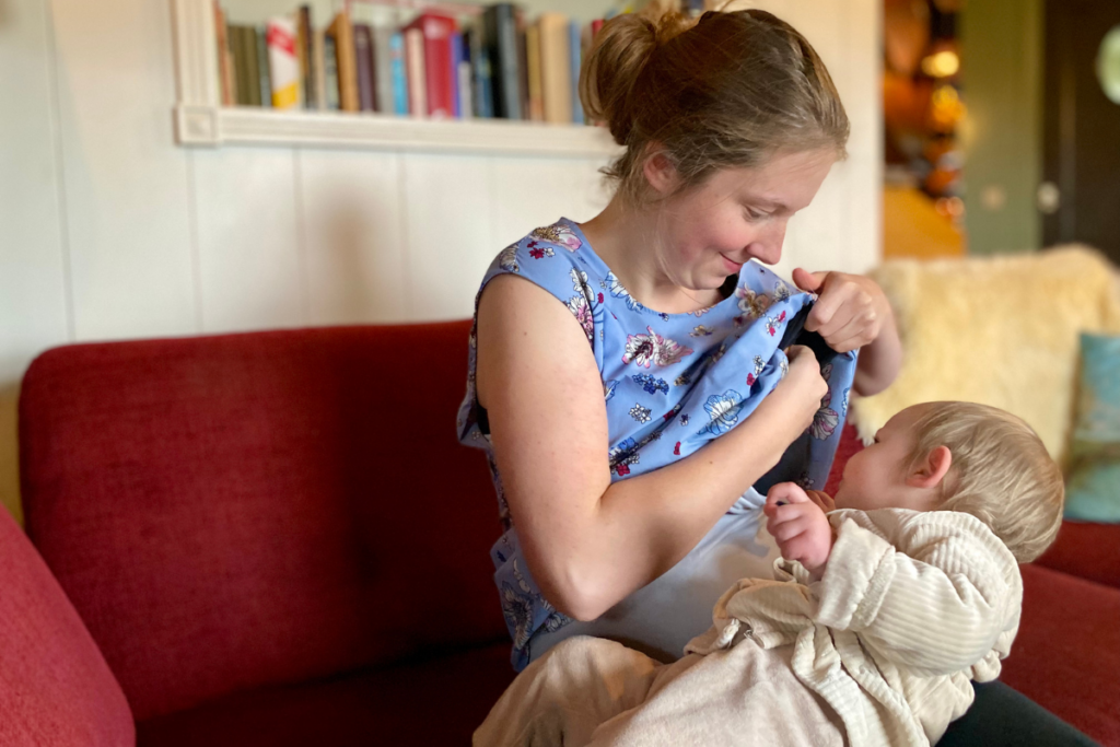 women unclothing herself to breastfeed her baby