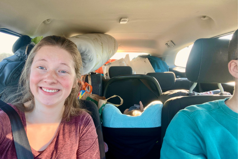 selfie of women in a full car with car seat behind her