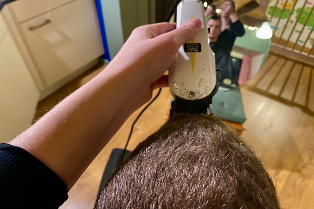 close up of hair clipper shaving hair from the front to the back of a man's head