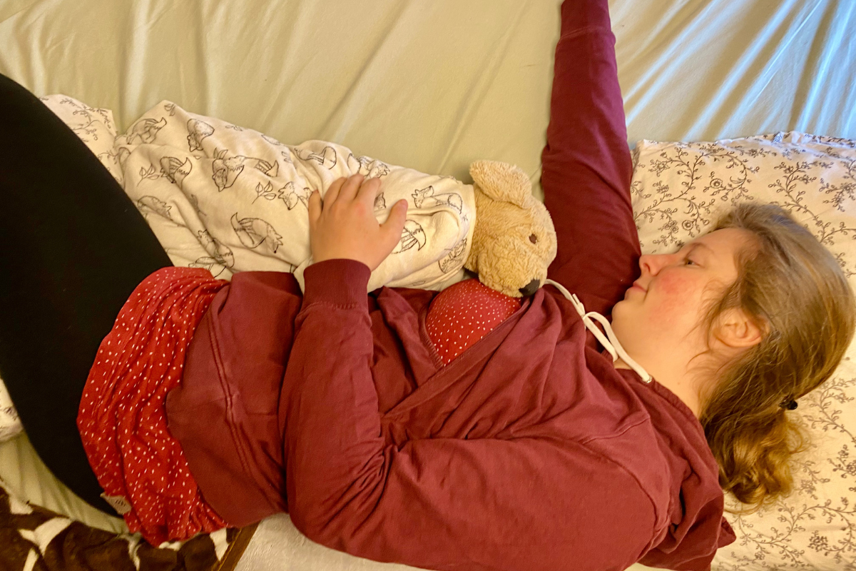 women demonstrating how to breastfeed while bed sharing