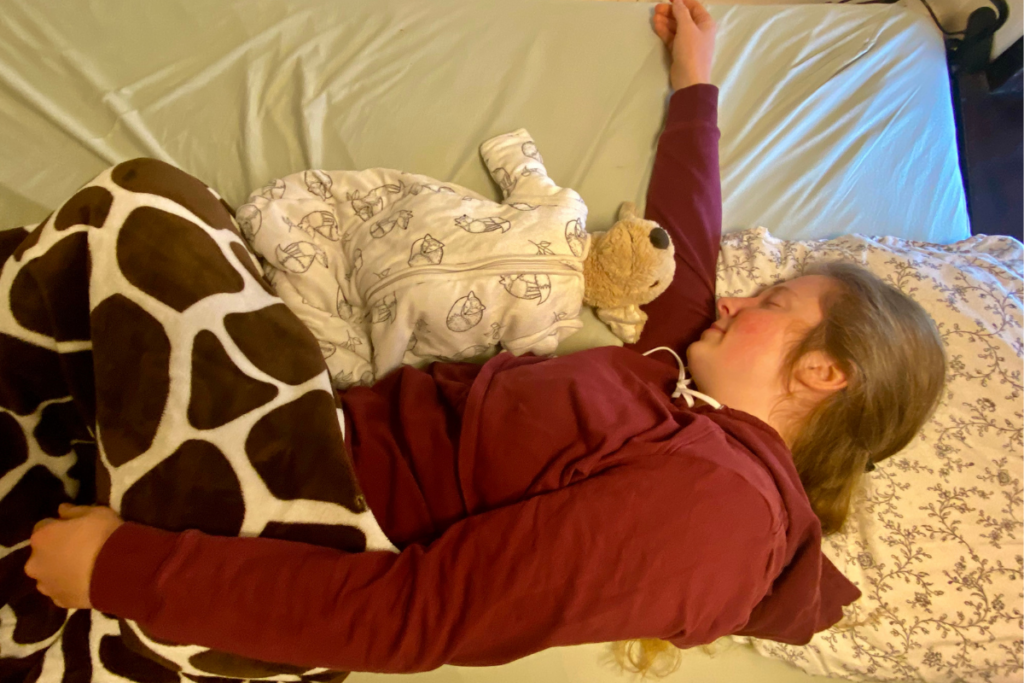 women showing how to safely do bed sharing using a toy pet as a newborn