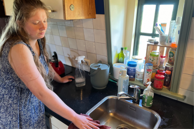 women standing in kitchen and cleaning