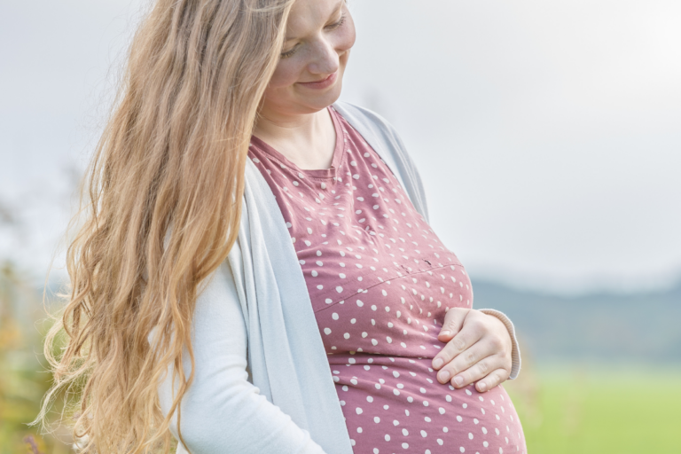 Pregnant women holding her bump with open hair